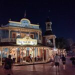 Mobile Order Disney: fachada iluminada de noche de Pecos Bill Tall Tale Inn and Cafe, local de comida rápida en Magic Kingdom